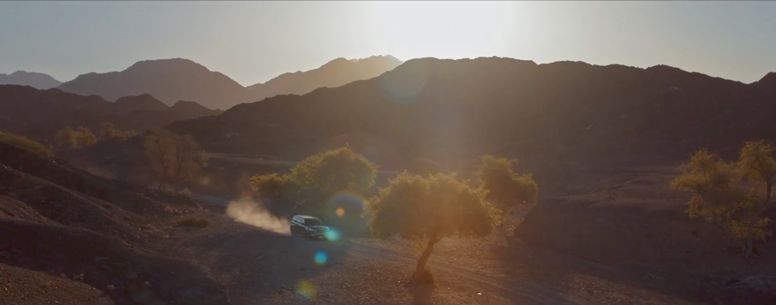 a car driving down a dirt road in the mountains