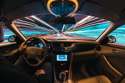 a man driving a car at night with a lot of lights