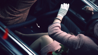 a woman sitting in a car with a glove on her hand