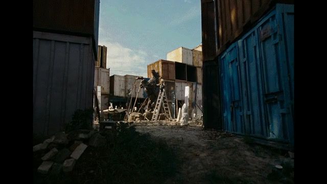 a man standing on a ladder in front of a building