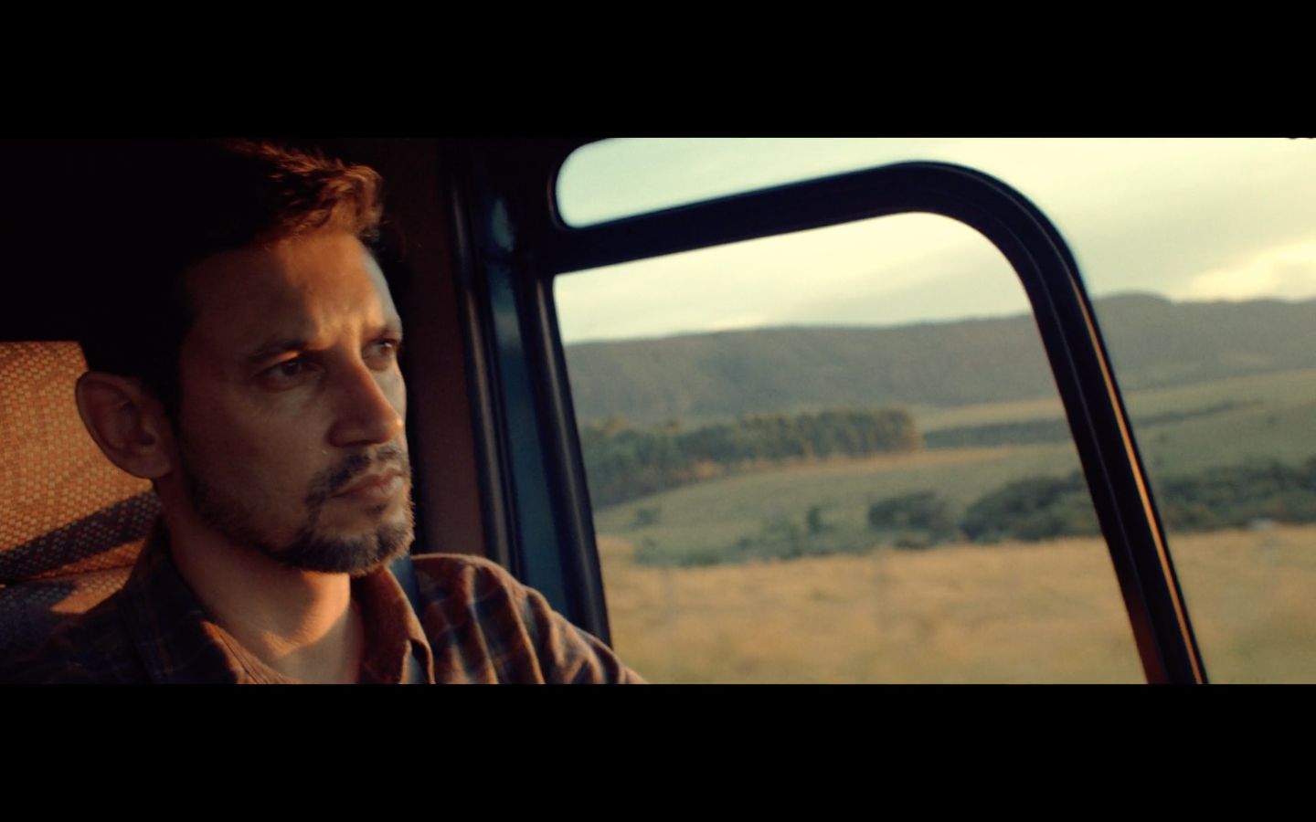 a man sitting in a vehicle looking out the window