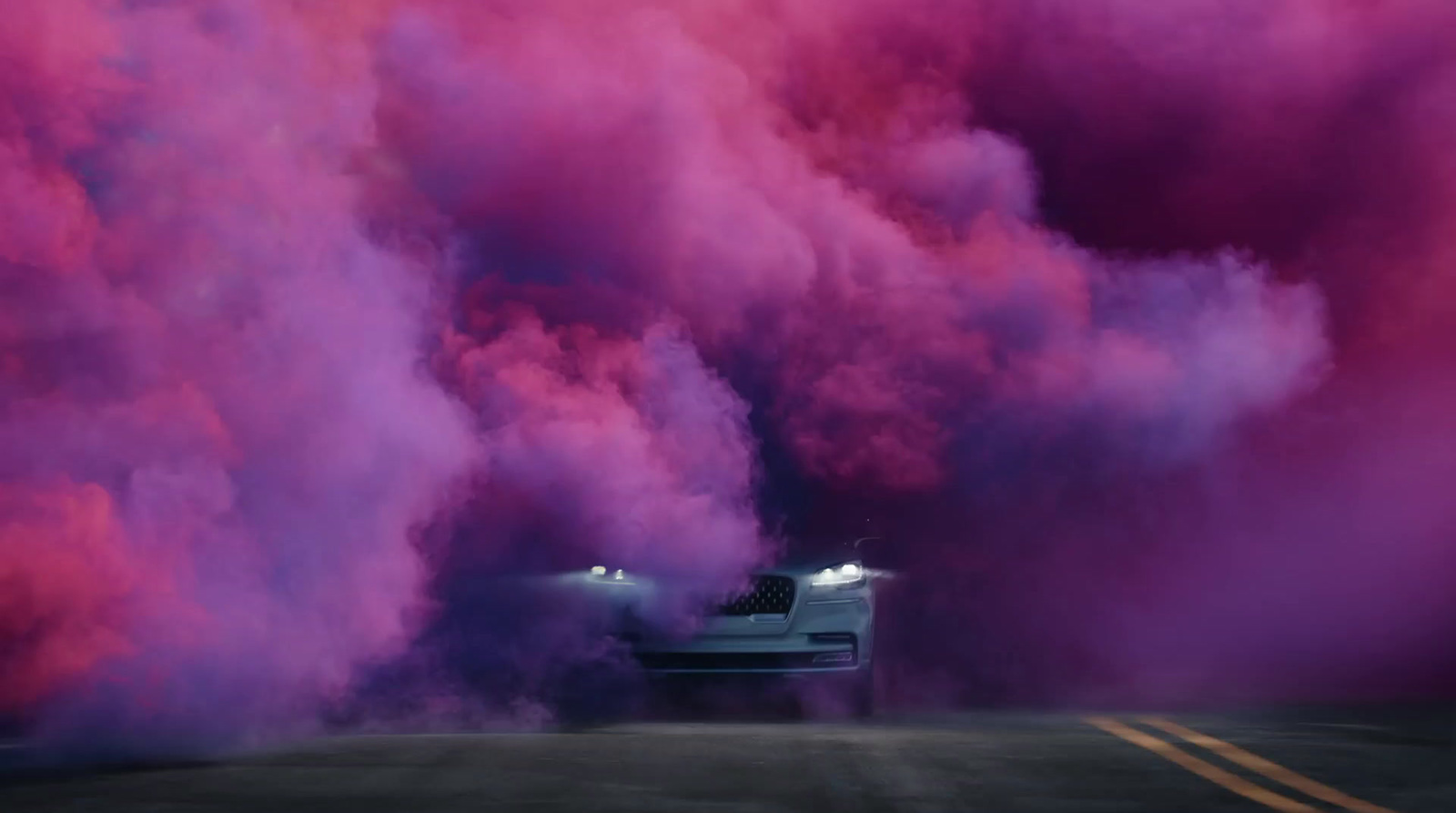 a car driving down a road surrounded by purple smoke