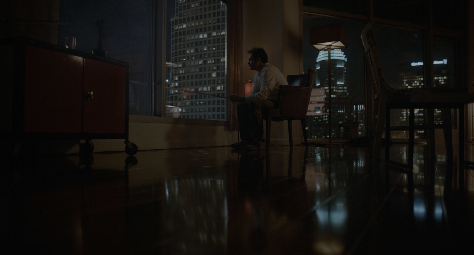 a man sitting in a chair in a dark room