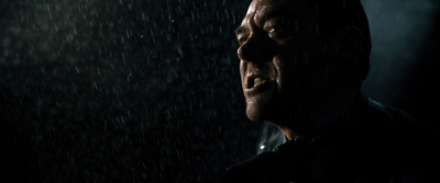 a man standing in the rain in the dark