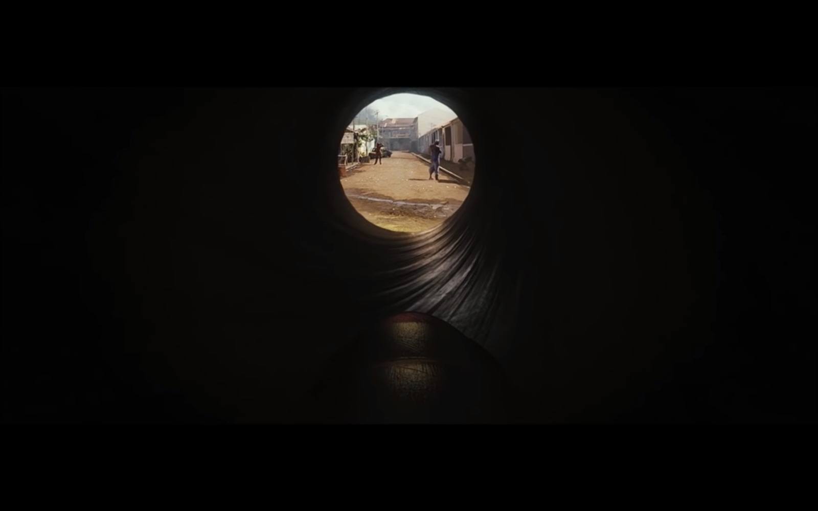 a view of a person walking out of a tunnel