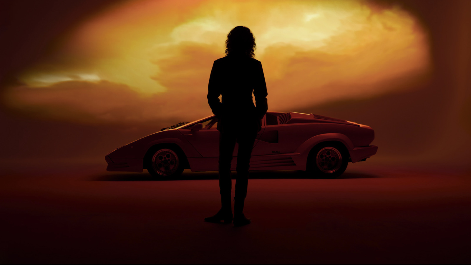 a woman standing in front of a red car