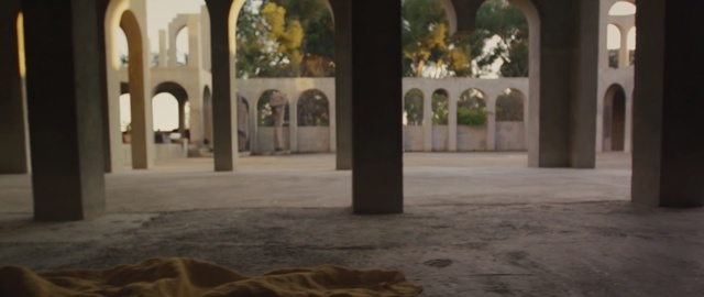 an empty room with arches and a blanket on the floor