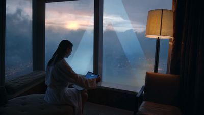 a woman sitting on a bed looking out a window