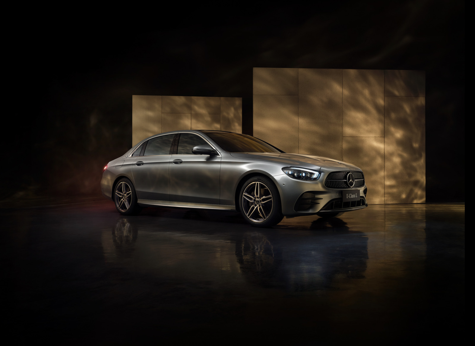 a silver car parked in front of a wall