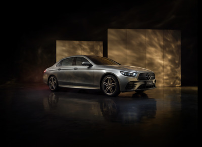 a silver car parked in front of a wall