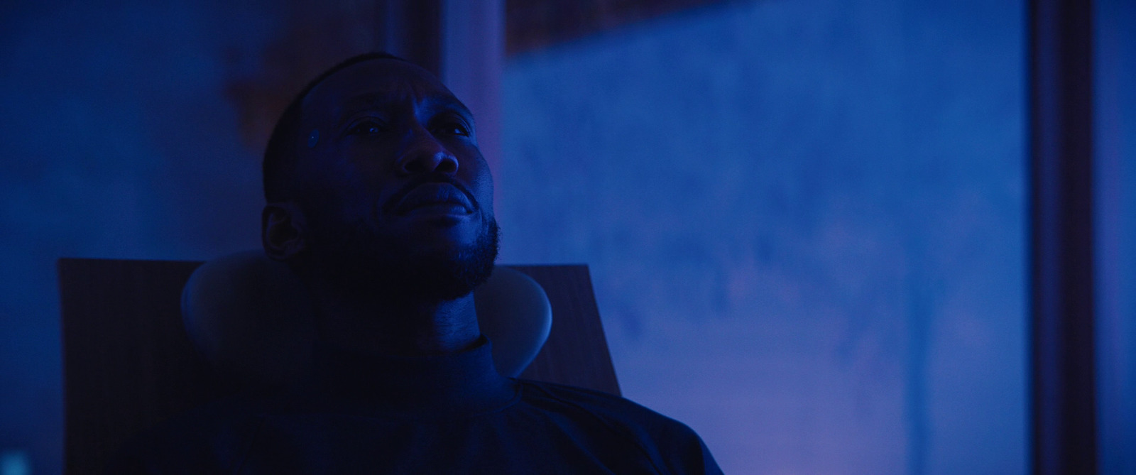 a man sitting in a chair in a dark room