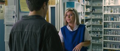 a woman talking to a man in a pharmacy