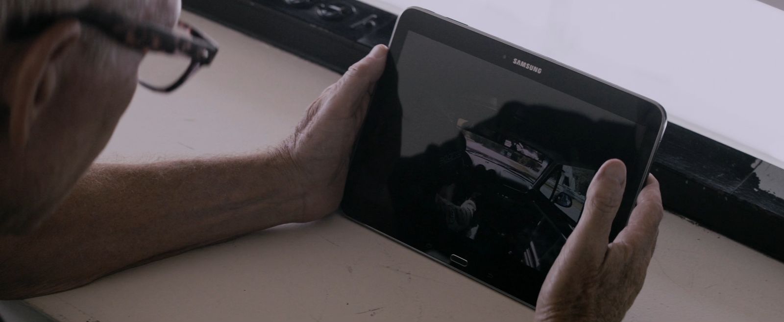 a man holding an electronic device on a table