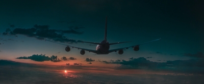 an airplane is flying over the clouds at sunset