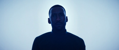 a man in a black shirt standing in front of a white background