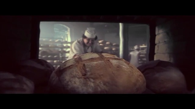 a man standing in front of a tv holding a loaf of bread