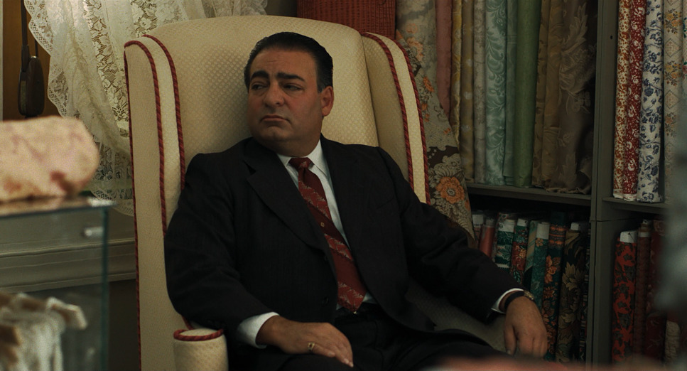 a man in a suit and tie sitting in a chair