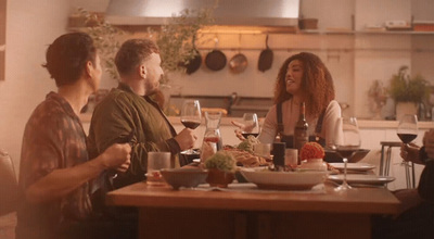 a group of people sitting around a table drinking wine