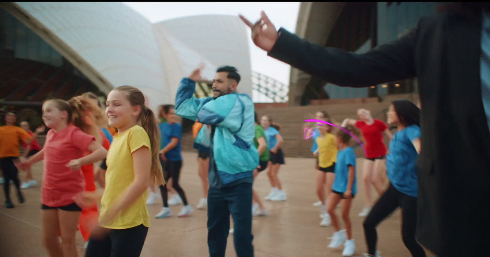 a group of people dancing in front of a building