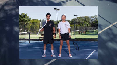 a man and woman standing on a tennis court holding racquets