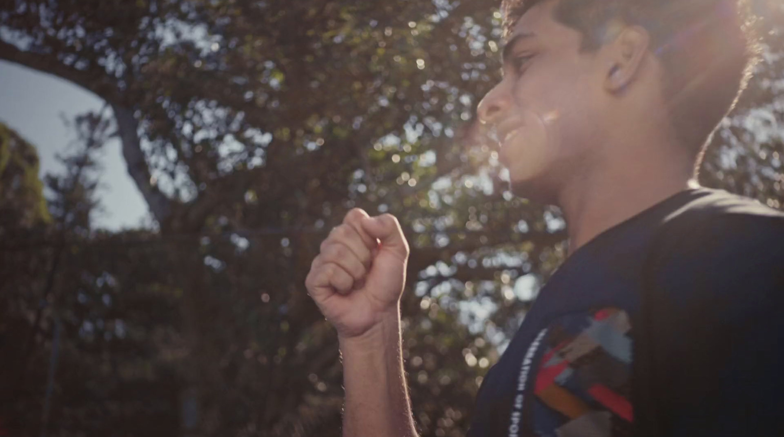 a man standing in front of a tree holding a cigarette