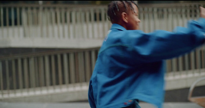 a man in a blue jacket throwing a frisbee