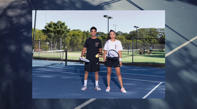 a man and woman standing on a tennis court holding racquets