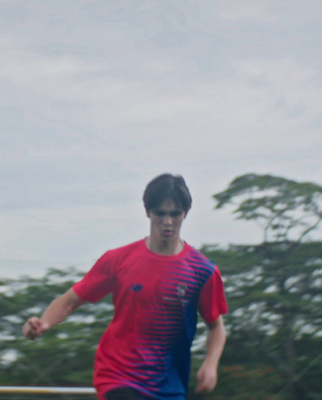 a man in a red and blue shirt is playing frisbee