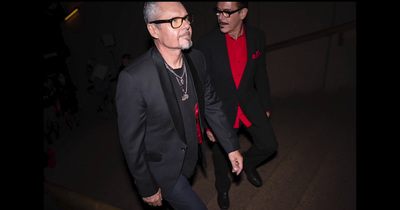 a man in a black suit and red shirt