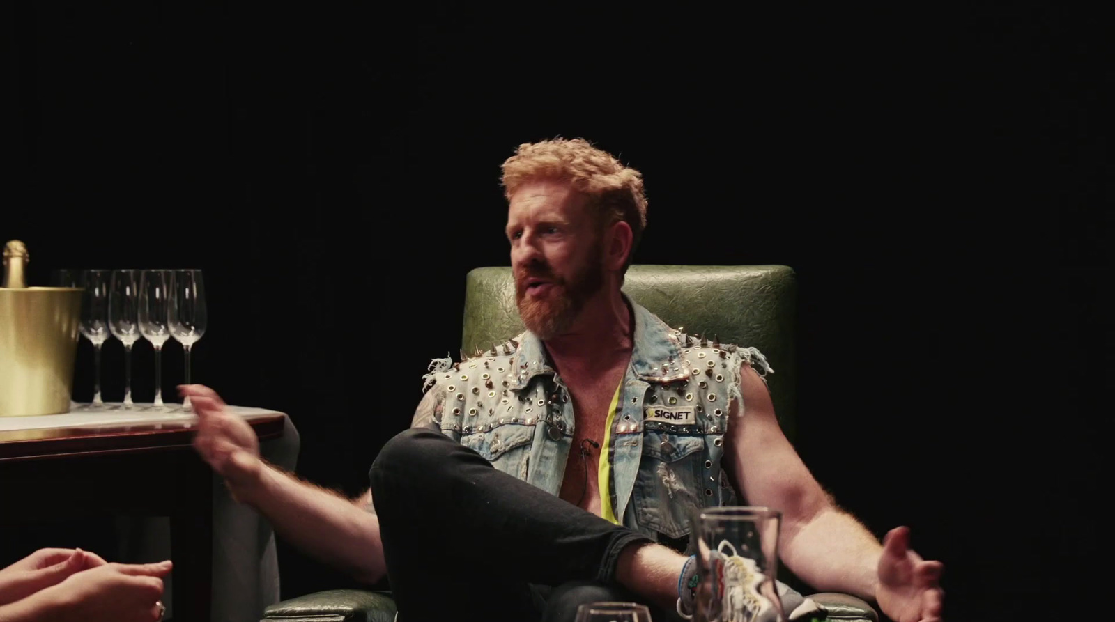 a man sitting in a chair with a glass of wine