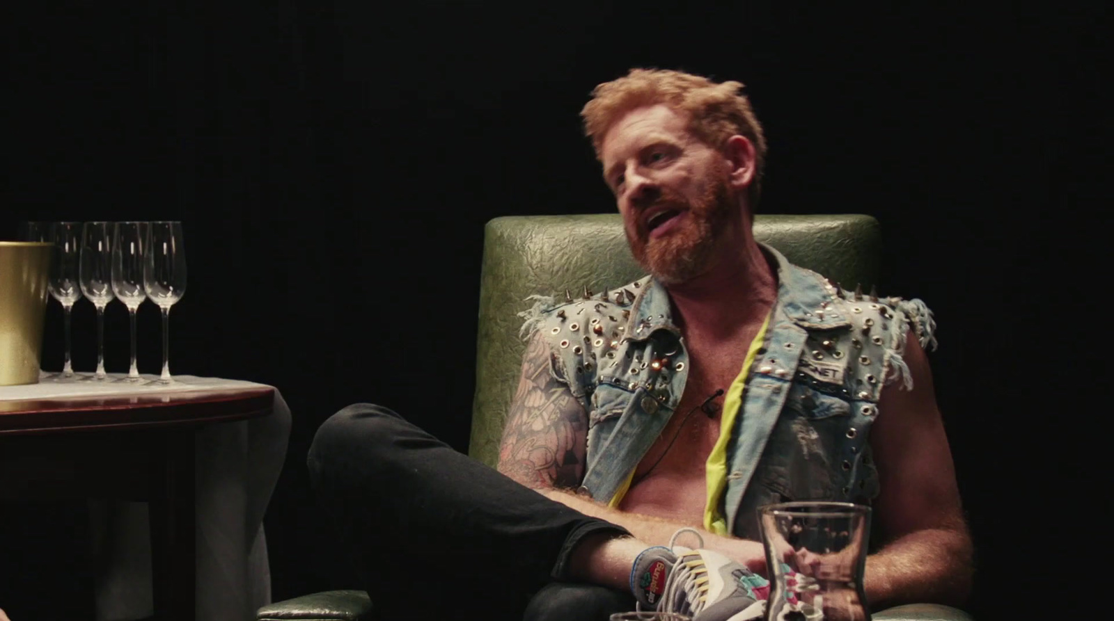 a man sitting in a chair with a glass of wine