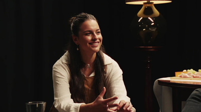 a woman sitting at a table talking to a man