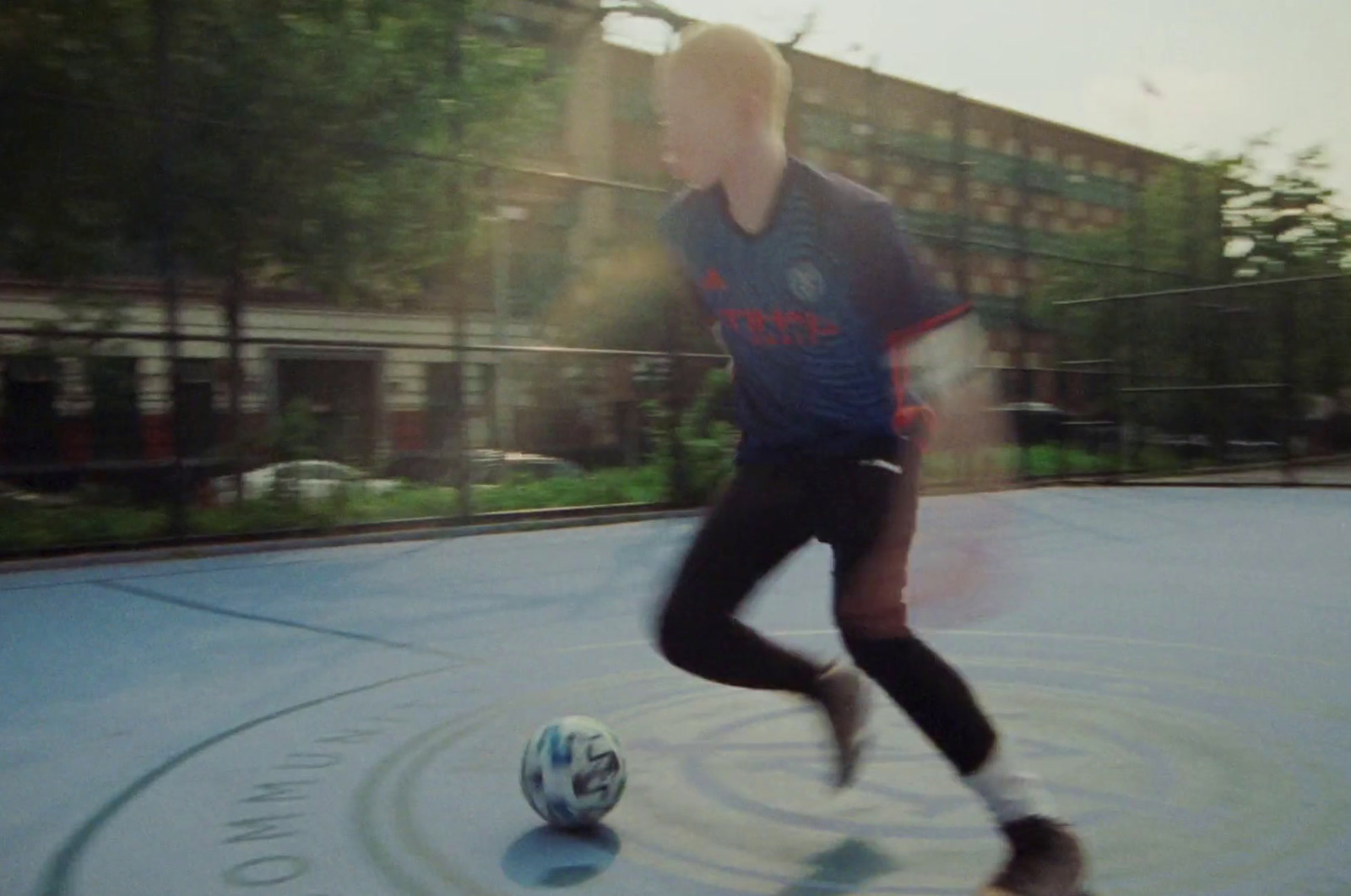 a man is kicking a soccer ball on a court