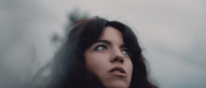 a woman with long black hair looking up into the sky