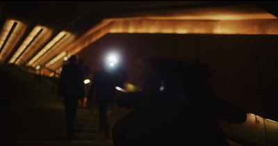 a group of people walking down a street at night