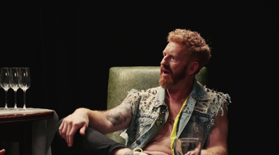 a man sitting in a chair with a glass of wine