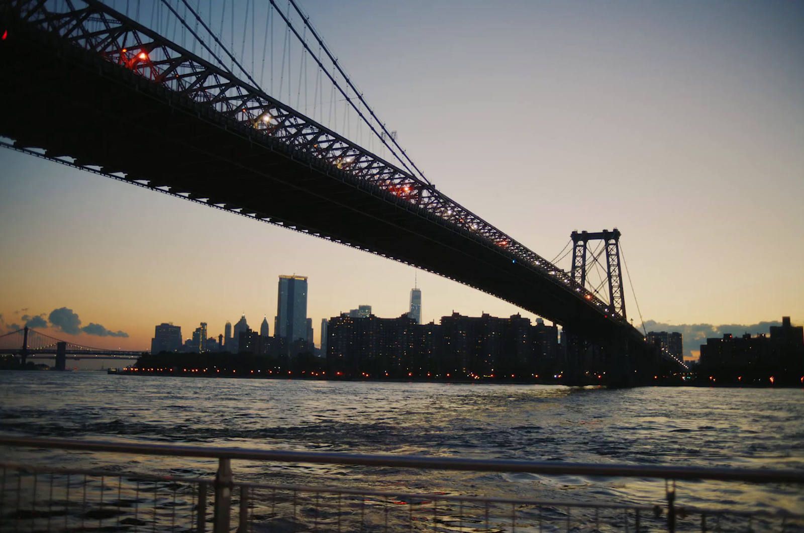 a bridge over a body of water with a city in the background