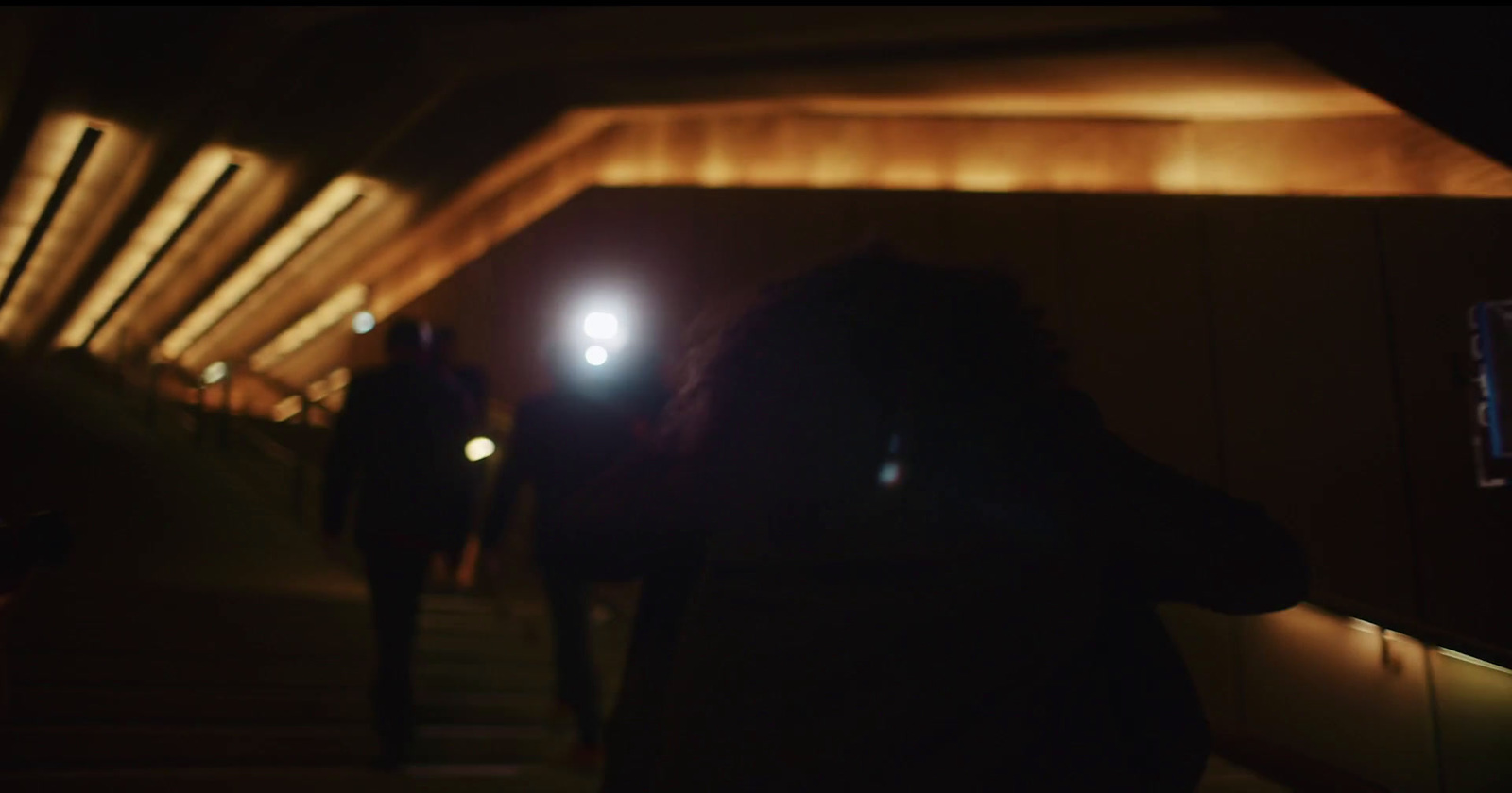 a blurry photo of people walking in a tunnel at night