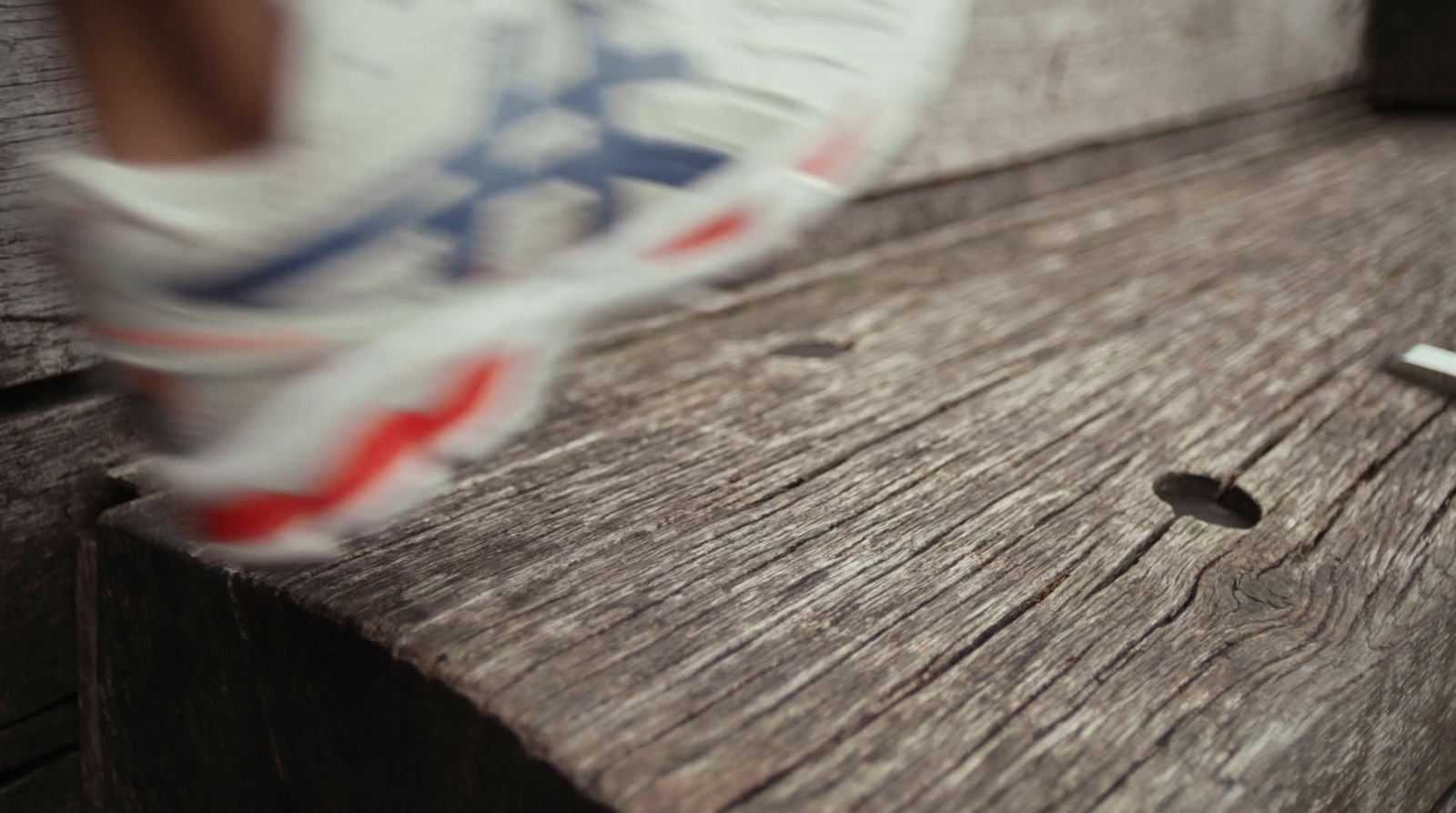 a close up of a person's shoe on a bench