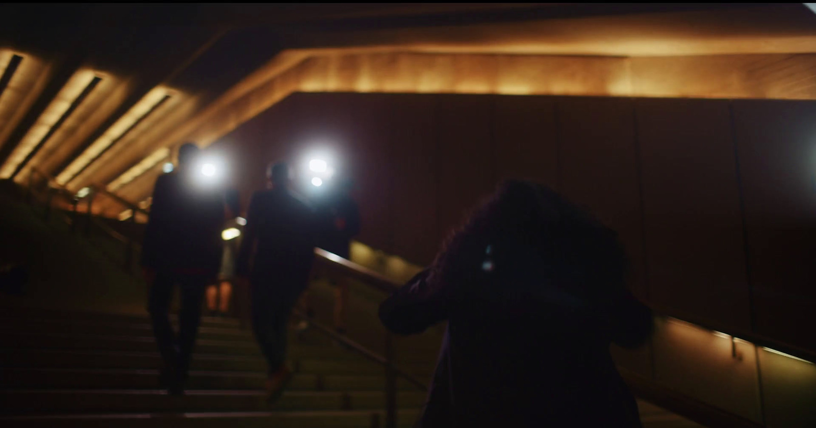 a group of people walking down a flight of stairs at night