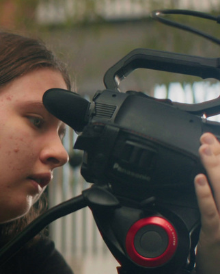 a woman holding a camera up to her face