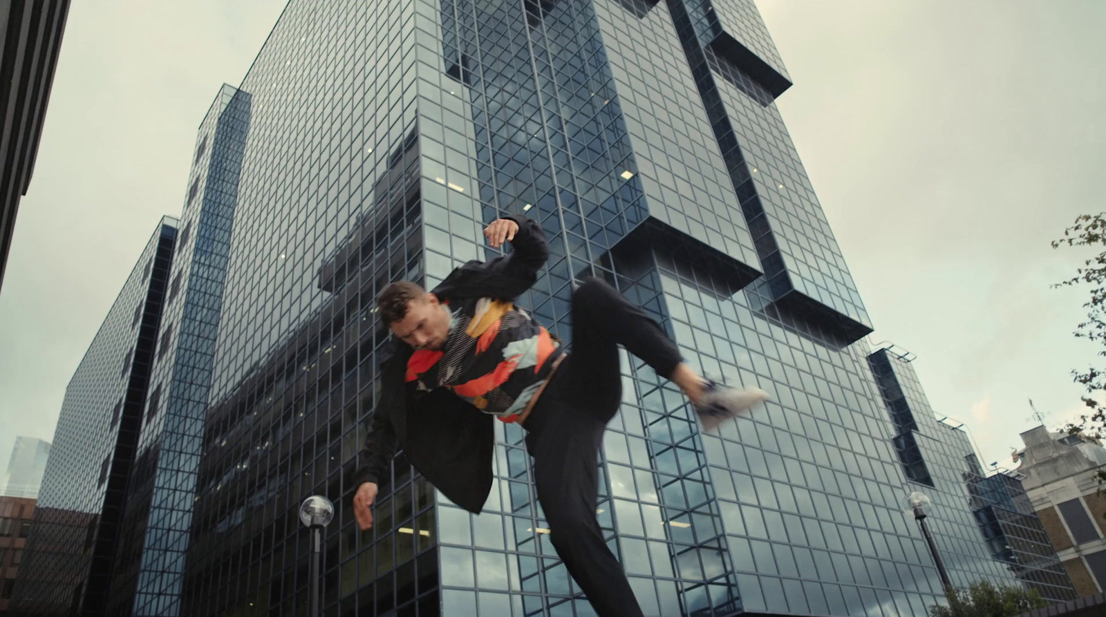 a man doing a trick on a skateboard in front of a tall building