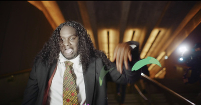 a man in a suit and tie holding a green paper