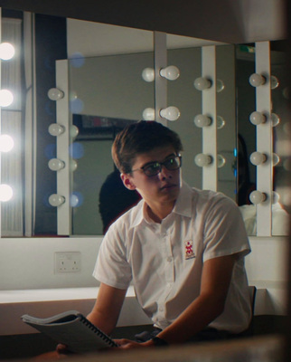 a man sitting in front of a mirror holding a cell phone