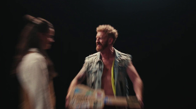 a man and a woman standing in front of a black background