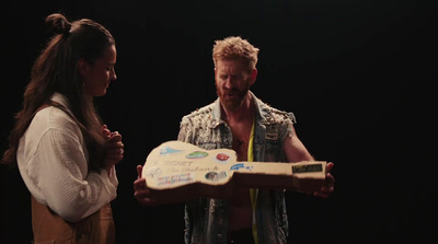 a man and a woman are holding a cake