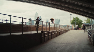 a man standing on top of a bridge next to a metal railing