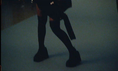 a woman in black boots and a black purse