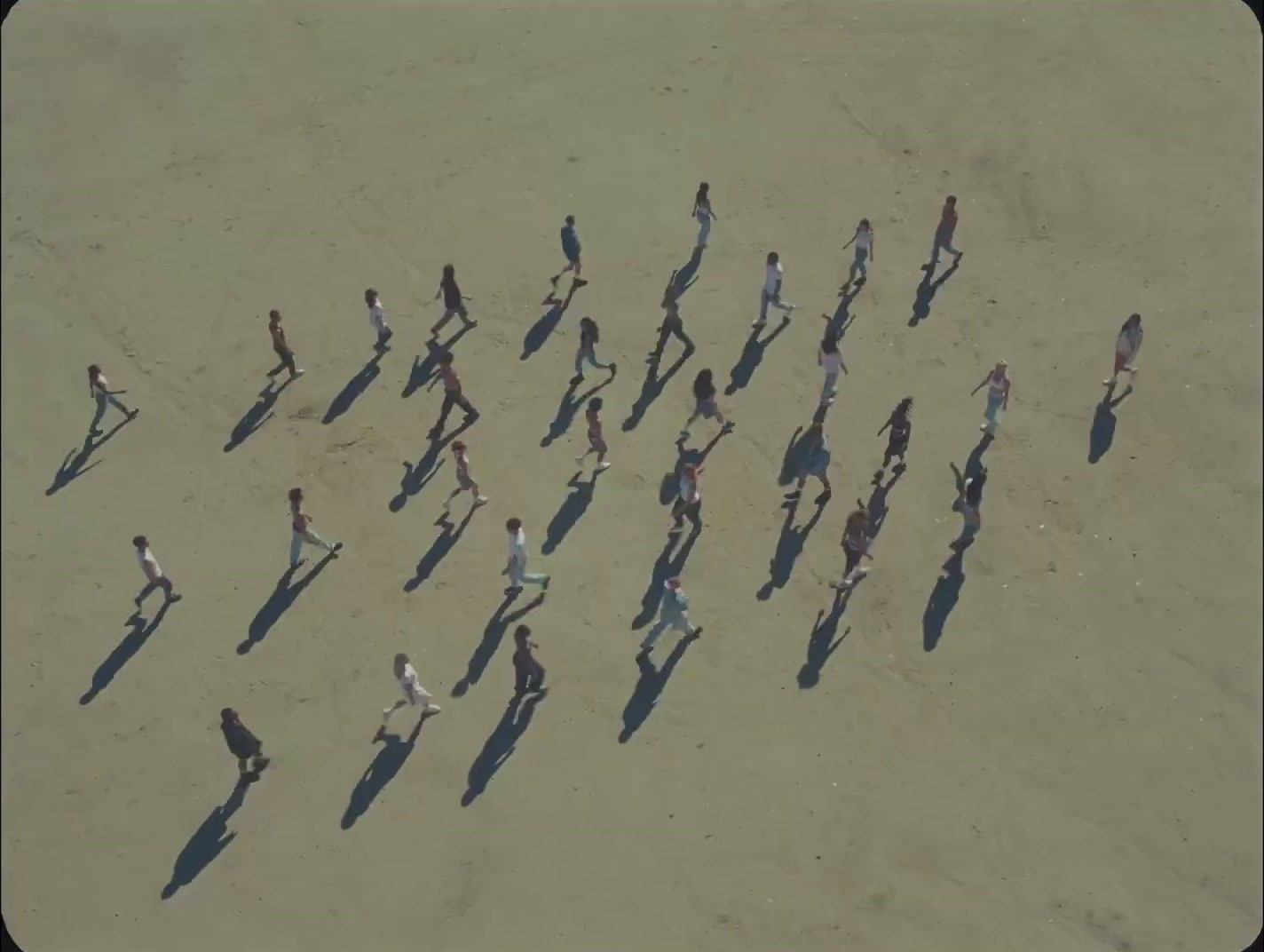 a group of people walking across a sandy beach