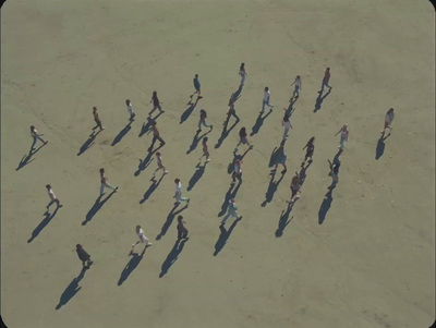 a group of people walking across a sandy beach